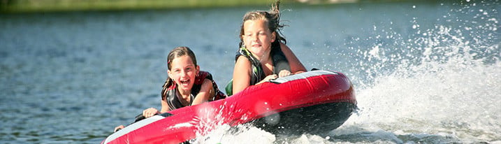 Kids Floating Behind Boat